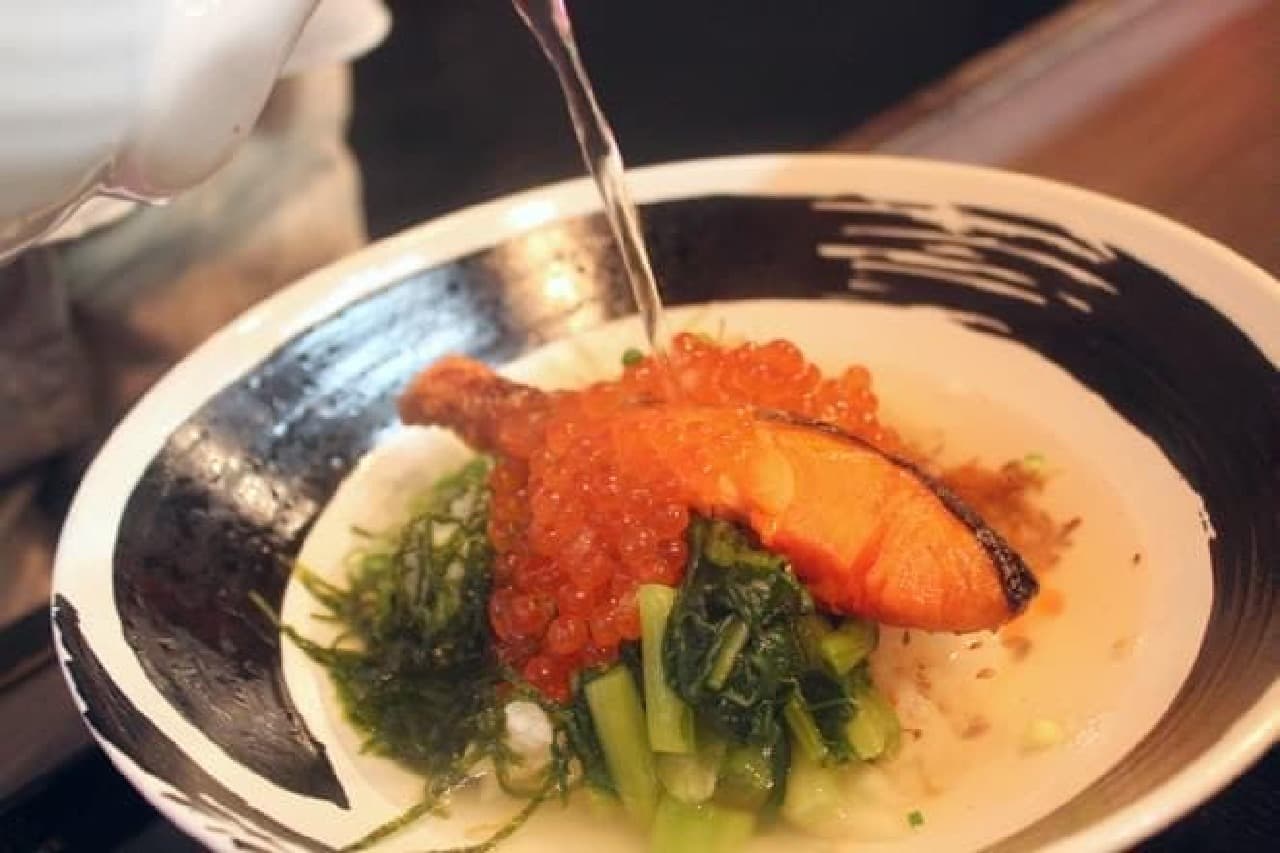 A new sensation of pouring soup stock on grilled salmon and salmon roe