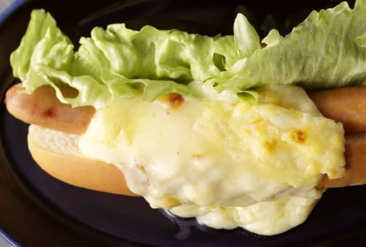 A hot dog with plenty of raclette cheese
