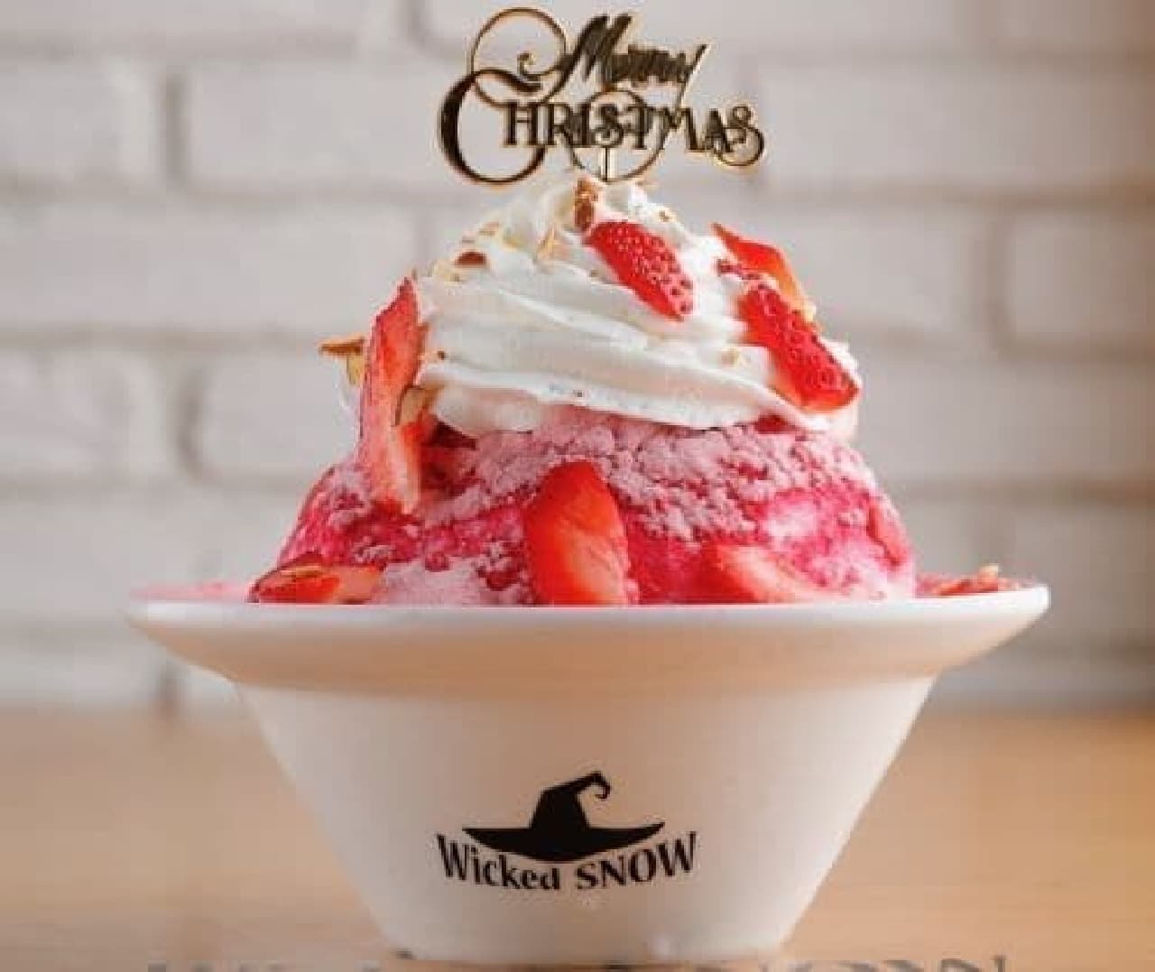 Wicked Santa is a shaved ice with berry sauce in fluffy shaved ice, strawberry powder on top, and strawberries on the toppings.