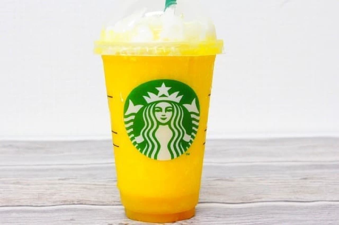 A cup of "Mango Passion Tea Frappuccino" with whipped cream and honey added