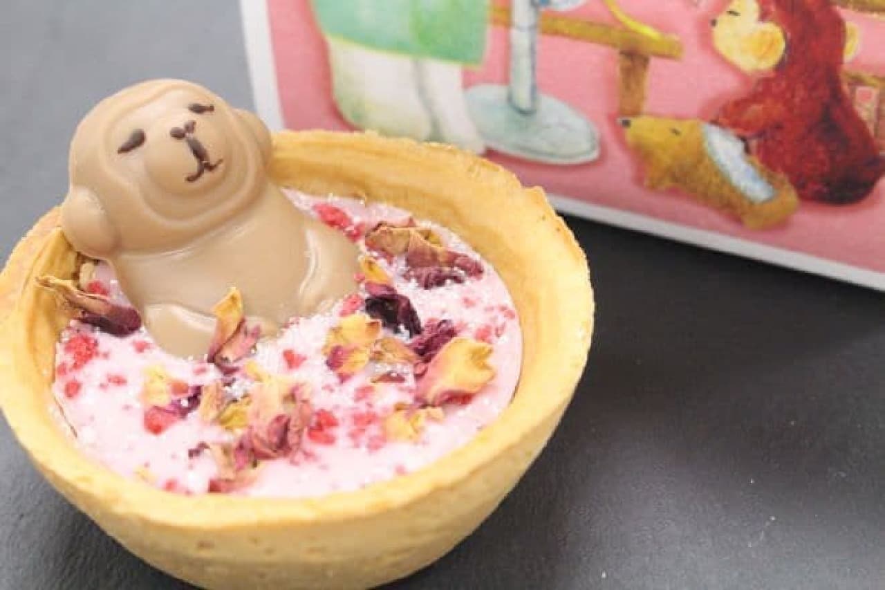 Saru Tart A is a dish sprinkled with strawberry chocolate, white chocolate monkey, rose flower ornament, raspberry granules, and silver powder sugar.