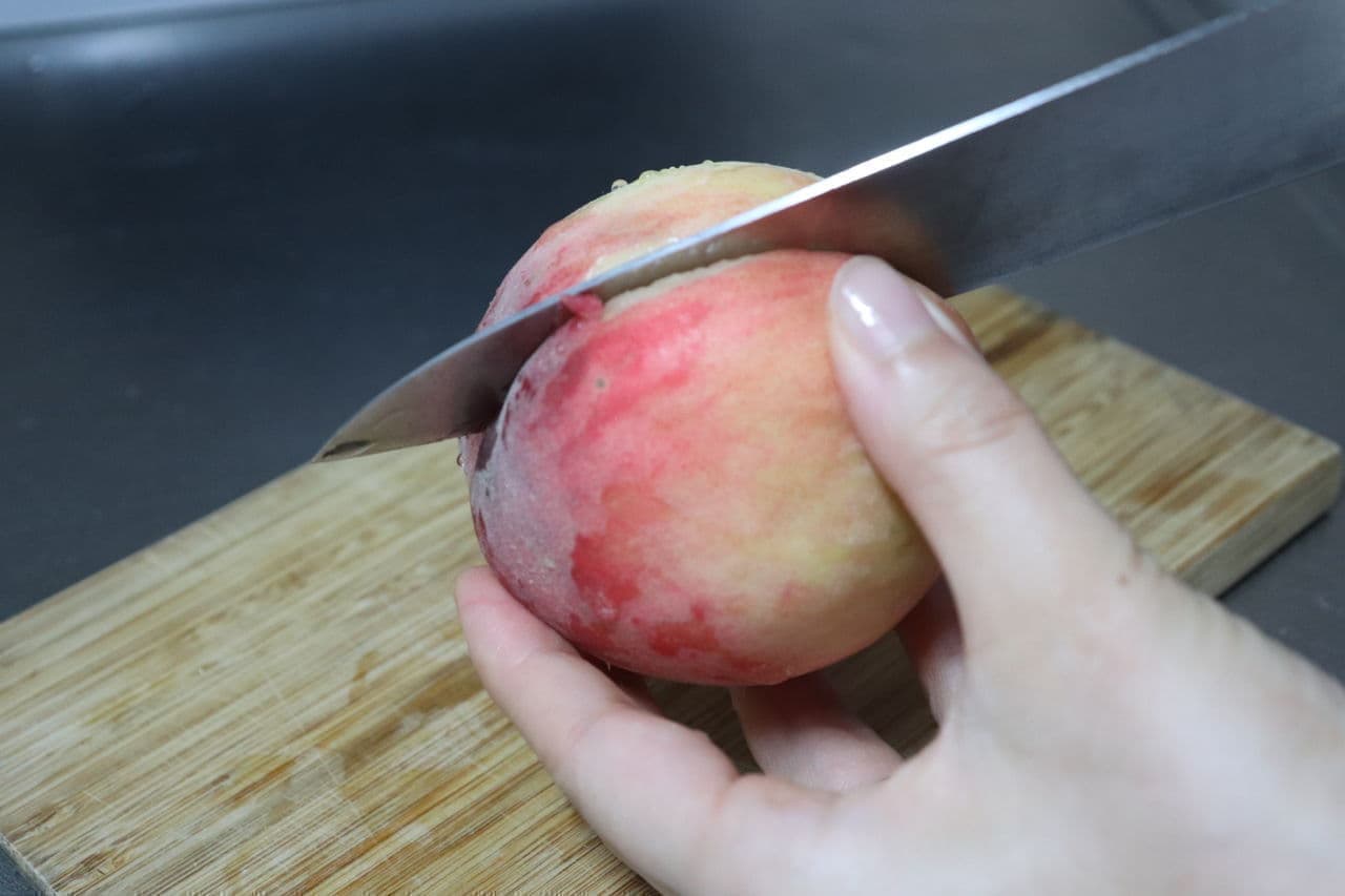 ステップ2 桃のすじに沿うように包丁を入れ、種の周りをぐるっと一周切れ込みを入れる。