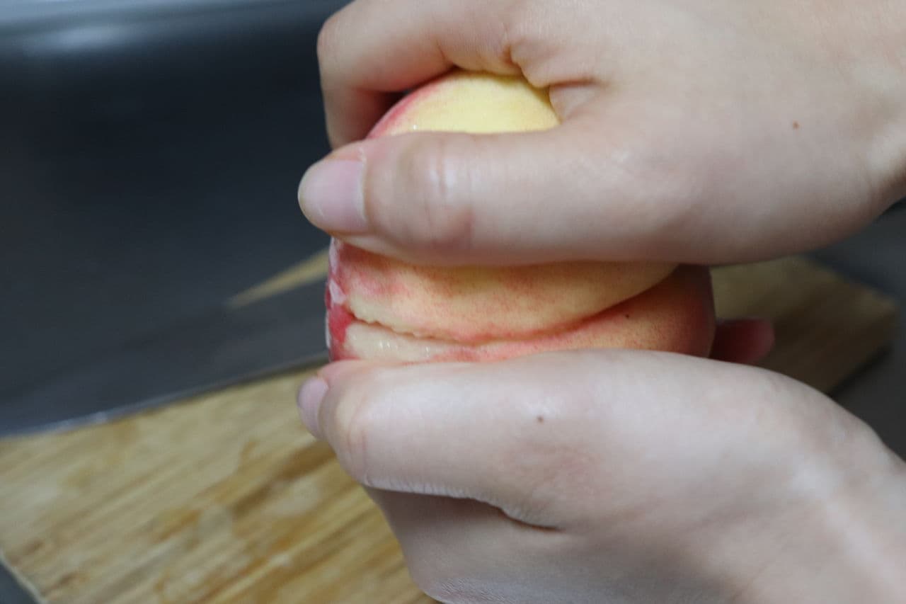 ステップ3 切れ込みを挟んで桃の両側を手で持つ。