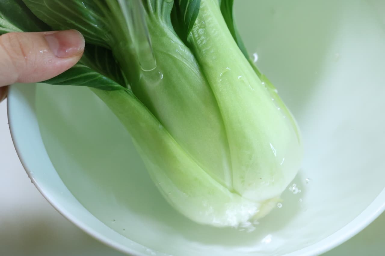 ステップ2 ボウルにチンゲン菜を入れ、茎の部分に流水をあてて、ふり洗いします。