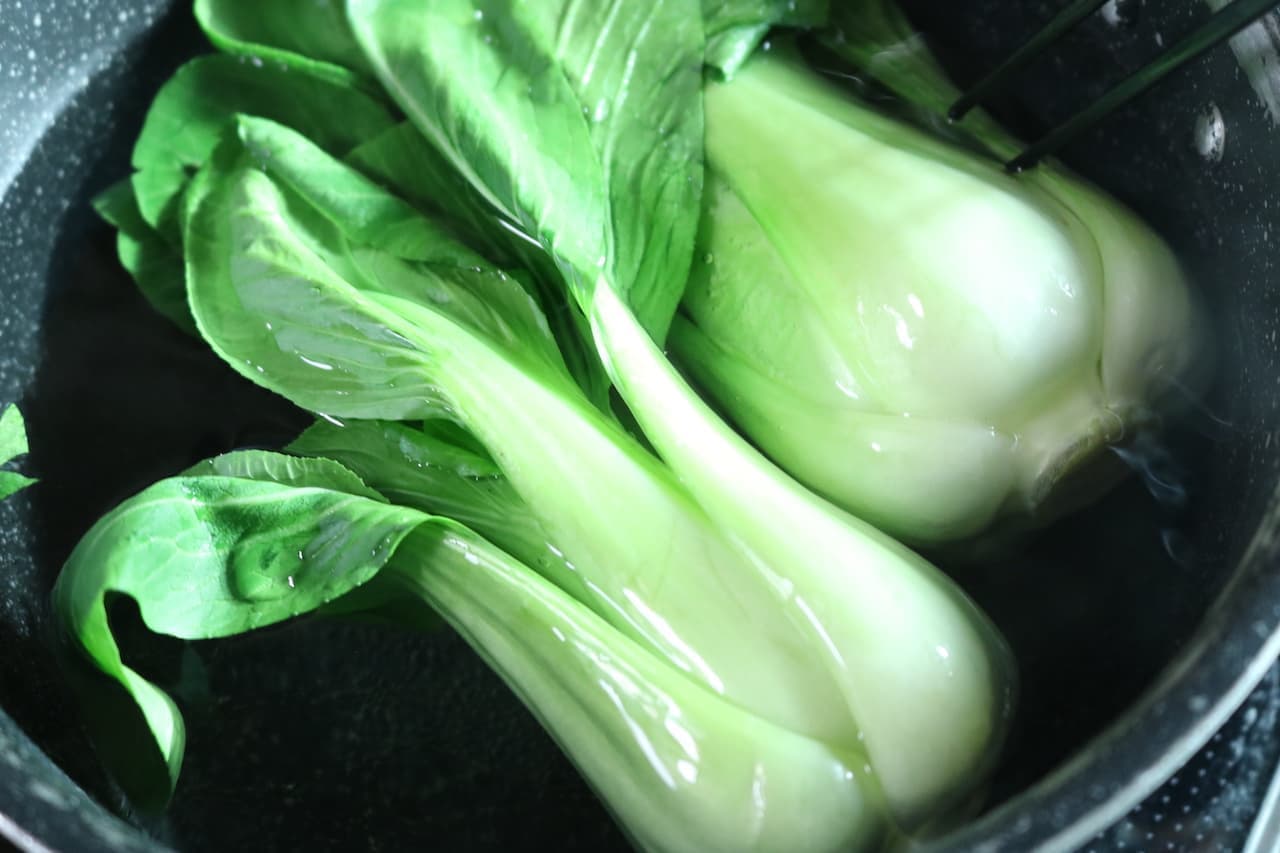 Step 4 Then, using chopsticks or other tools, submerge the whole bok choy and boil for another 20 seconds.