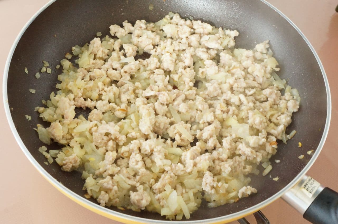 Onions and chicken being pan-fried
