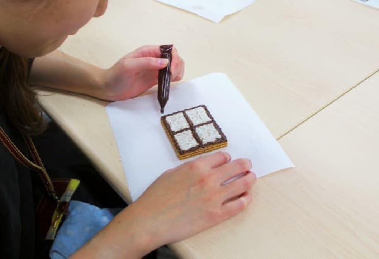 The windows are decorated with a chocolate pen on the wafer.