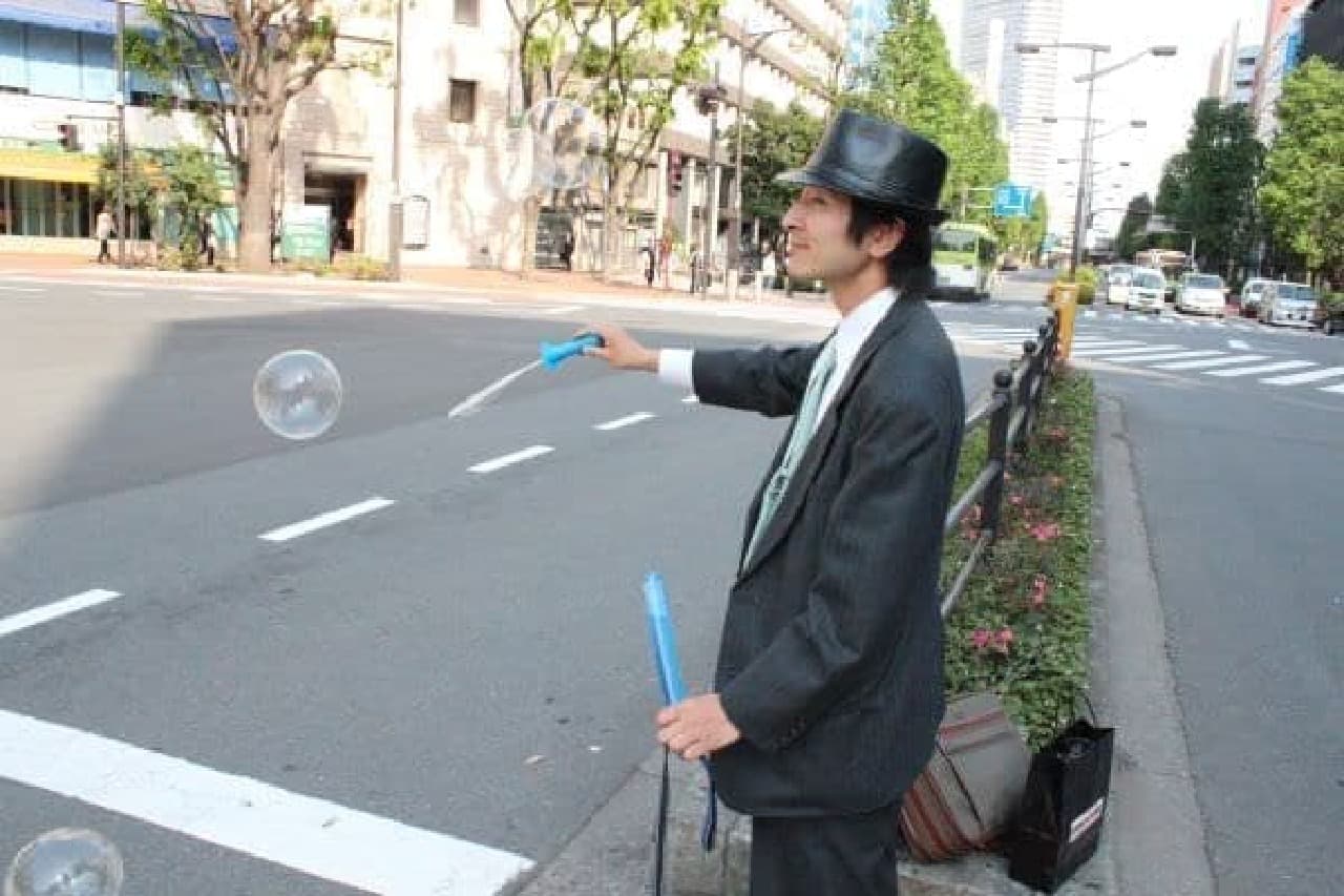 Mr. Naganuma flying soap bubbles while waiting for a traffic light
