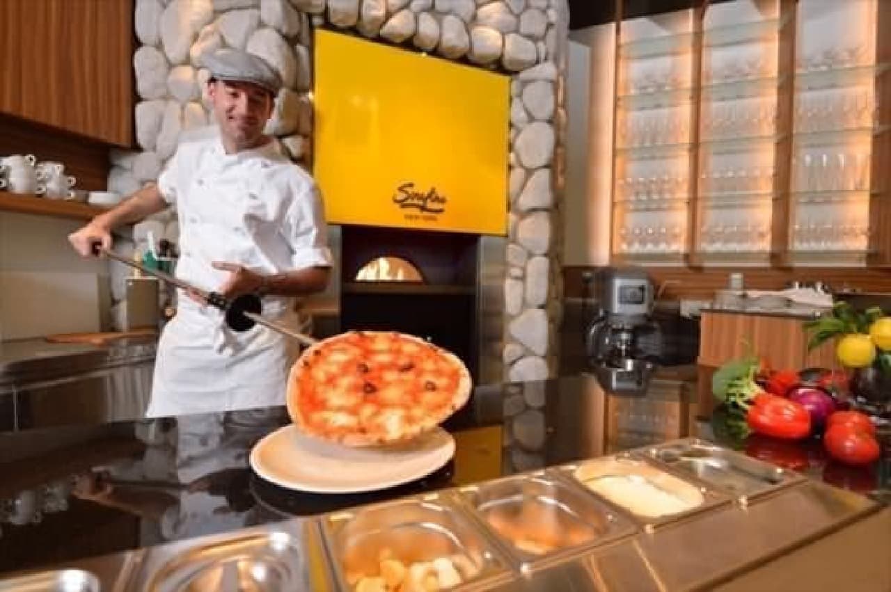 Have a meal while watching the skill of a pizza chef