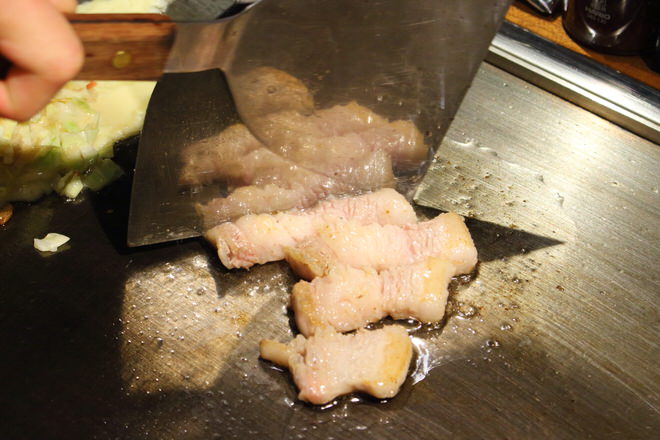 ヘラで豚肉をカット-お好み焼き